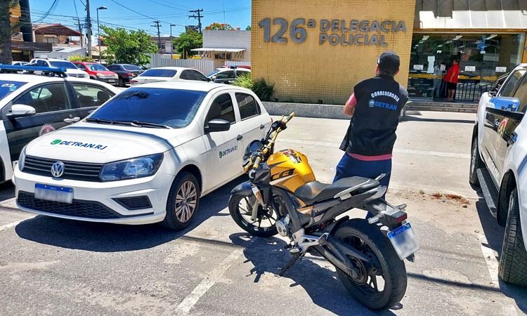 Funcionário do Detran fazendo a apreensão da moto clonada