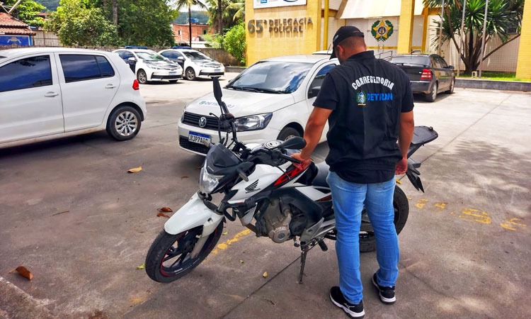 agente de fiscalização do Detran verifica moto apreendida