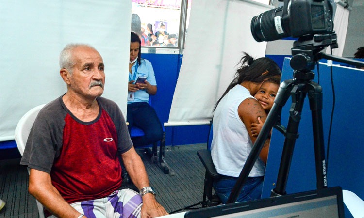 Um senhor realizando a emissão da sua nova carteira de identificação civil