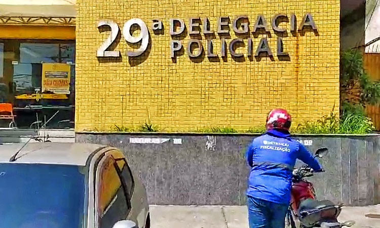 agente de fiscalização do Detran conduz moto para frente da 29ª Delegacia de Polícia