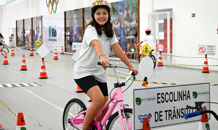 aluna participa de evento, pedalando em circuito que simula trânsito