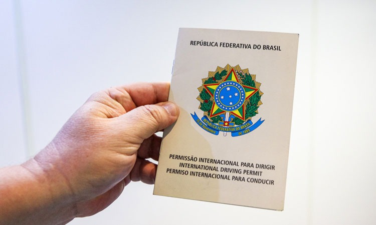 mão de um homem segurando o documento PID (permissão internacional para dirigir)
