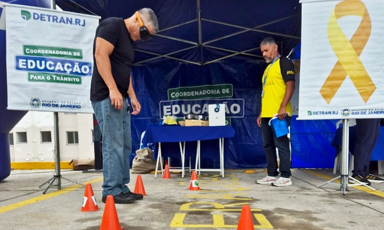 Homem participa de atividade com óculos do Detran que simulam reações ao dirigir sob o efeito de com álcool, drogas e sono