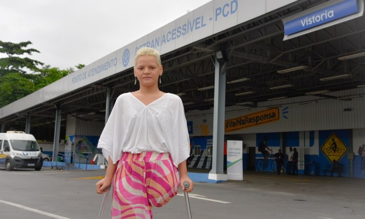 Mulher deficiente física posa para foto dentro do Posto Detran Acessível