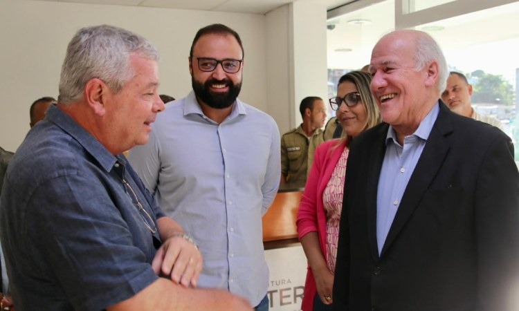 três homens e uma mulher conversam sorridentes durante inauguração de Posto de Identificação Civil