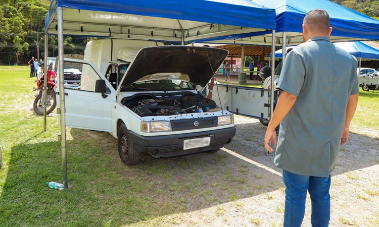 Funcionário do Detran faz vistoria em veículo com capô aberto