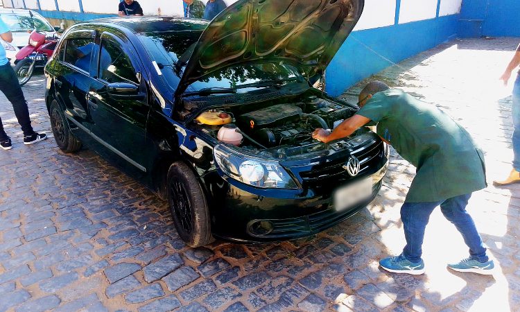 Funcionário do Detran faz vistoria em veículo com capô aberto