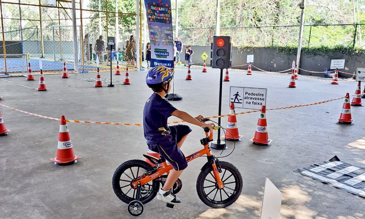 criança andando de bicicleta em circuito simulando o trânsito