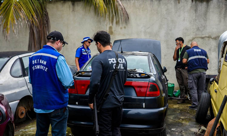 Agentes da Operação Desmonte analisam o carro roubado encontrado no ferro-velho