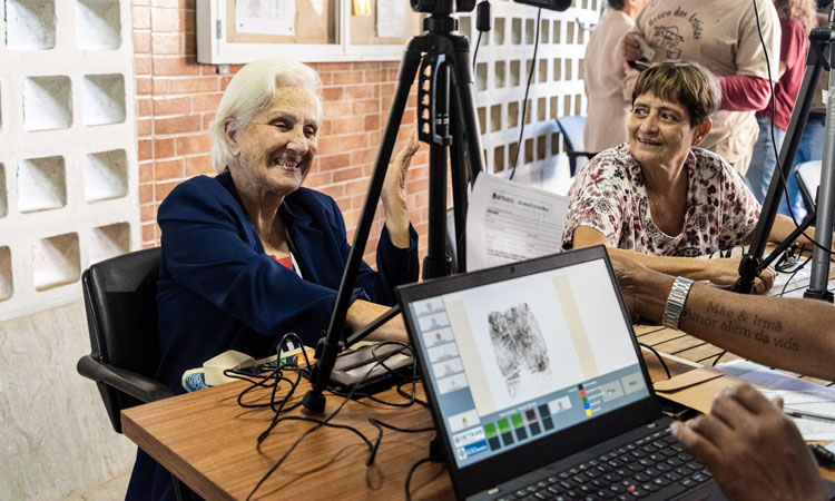 Claire Digon sorri ao tirar a carteira de identidade no Retiro dos Artistas