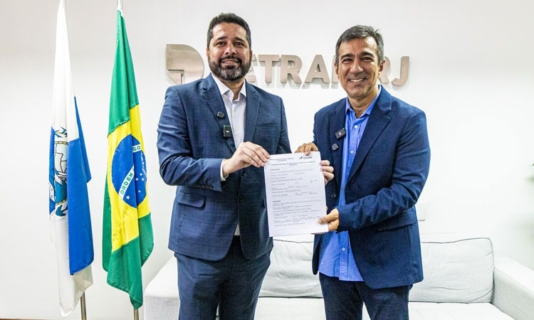 Fabiano dos Santos, presidente dos Correios, e Vinicius Farah, presidente do Detran RJ, exibem o contrato que permitirá a entrega de documentos do Detran pelos Correios