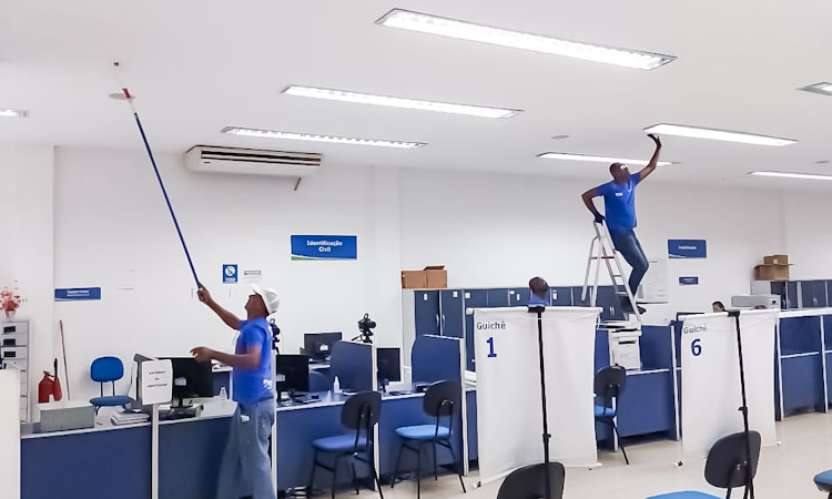 Trabalhadores pintam o teto de posto de atendimento do Detran RJ