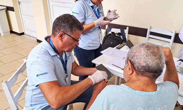 Funcionário do Detran RJ colhe as digitais de idoso na Casa São Luiz, no Caju