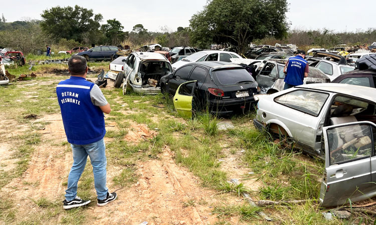 Agente do Detran observa as sucatas de veículos no ferro-velho