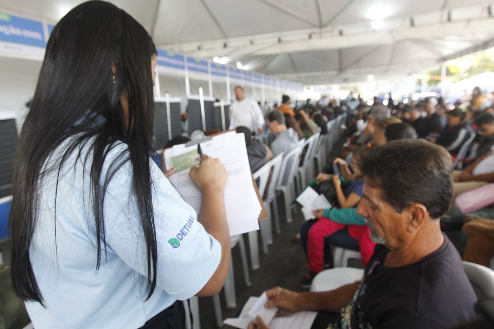 Atendente do Detran anota informações de usuário no Detran Presente de Cabo Frio