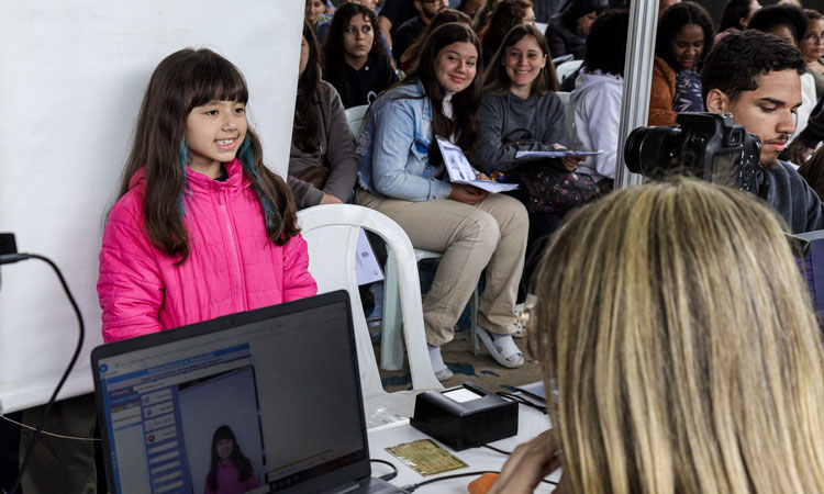 Uma menina é fotografada para tirar a carteira de identidade no Detran Presente de Petrópolis