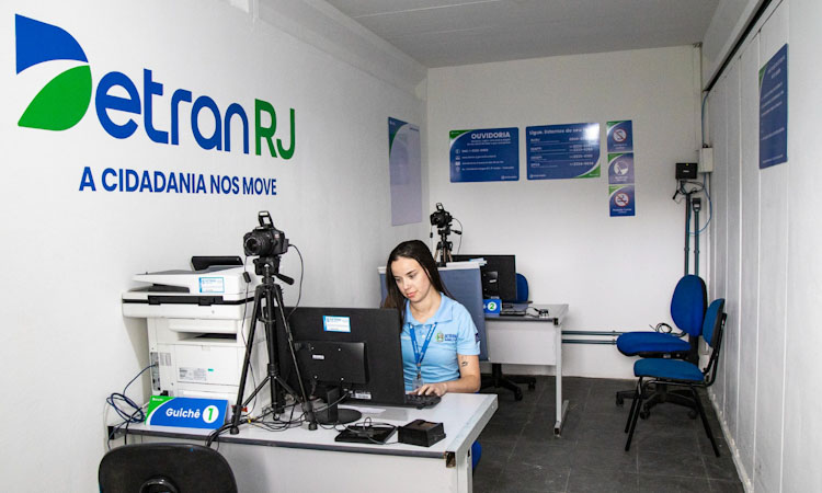 Atendente do posto sentada em sua posição de trabalho diante do computador