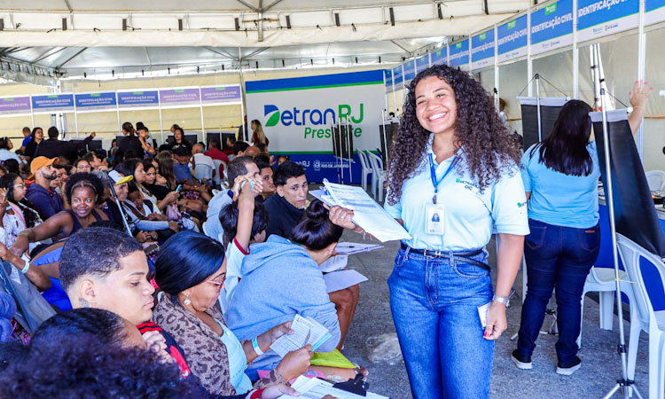 Atendente do Detran sorri para o fotógrafo enquanto organiza os moradores de Búzios para o atendimento no setor de identificação civil